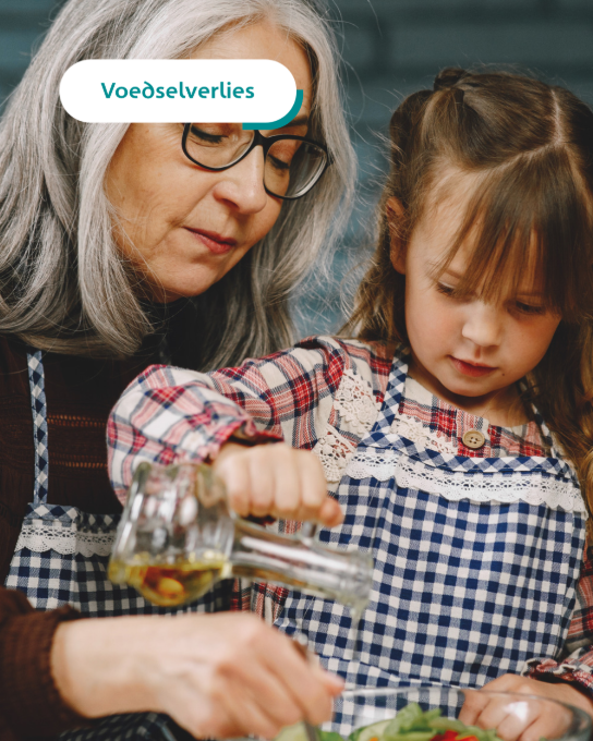 Oma en kleindochter koken samen, met tekstballon "Voedselverlies" bovenaan. (vergroot foto)